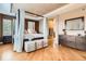 Spacious main bedroom boasts a tray ceiling, light wood floors and canopy bed with many windows at 4965 Huntwick Pl, Highlands Ranch, CO 80130