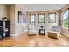 Inviting sitting area with two chairs, three windows, light-colored walls, and hardwood flooring at 4965 Huntwick Pl, Highlands Ranch, CO 80130