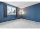Cozy bedroom with gray carpet, blue accent wall, and natural light from the window at 2067 E Phillips Pl, Centennial, CO 80122