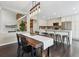 Open-concept dining room adjacent to kitchen, featuring dark wood floors and a modern light fixture at 2067 E Phillips Pl, Centennial, CO 80122