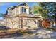 Two-story home showcasing a two-car garage, driveway, mature trees, and well-maintained landscaping at 2067 E Phillips Pl, Centennial, CO 80122