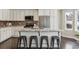 Kitchen island boasts granite countertops, seating for four, stainless steel appliances, and ample cabinet space at 2067 E Phillips Pl, Centennial, CO 80122