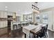 Well-lit kitchen boasts stainless steel appliances, an island with seating, and a dining area with modern lighting at 2067 E Phillips Pl, Centennial, CO 80122