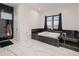 Elegant bathroom with marble walls, tiled floors, and a soaking tub under a window at 29780 E 162Nd Ave, Brighton, CO 80603