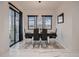 Formal dining room with sleek black table and chairs, illuminated by a modern chandelier at 29780 E 162Nd Ave, Brighton, CO 80603
