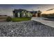 View of the house with a lush green lawn, rocks, and concrete driveway leading to modern garage doors at 29780 E 162Nd Ave, Brighton, CO 80603