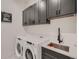 This laundry room features updated cabinets, appliances, and a sink at 29780 E 162Nd Ave, Brighton, CO 80603