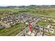 An aerial view showcases a home with solar panels in a beautiful community with mountain views at 6013 Eldora St, Golden, CO 80403