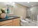 Luxurious bathroom with a glass-enclosed shower, modern fixtures, and vanity with dark countertops at 6013 Eldora St, Golden, CO 80403