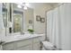 Well-lit bathroom with a large mirror, framed decor, and a shower with a white curtain at 6013 Eldora St, Golden, CO 80403
