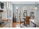 Bright breakfast nook with large windows, stylish seating, and hardwood floors at 6013 Eldora St, Golden, CO 80403