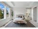 Serene main bedroom with tray ceiling, large windows, and a cozy seating area at 6013 Eldora St, Golden, CO 80403
