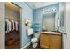 Well-lit bathroom with vanity, mirror, toilet, and walk-in closet with shelving at 20535 E 47Th Ave, Denver, CO 80249