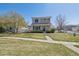 Charming two-story home with well-manicured lawn, mature tree, and inviting front entrance at 20535 E 47Th Ave, Denver, CO 80249