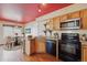 Traditional-style kitchen with wood cabinets, updated appliances, and adjacent eat-in dining area at 20535 E 47Th Ave, Denver, CO 80249