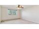 A bright bedroom with a large window, radiator heating, and neutral carpet at 585 S Alton Way # 6B, Denver, CO 80247
