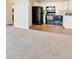 Open-concept kitchen with white cabinets and dark appliances at 585 S Alton Way # 6B, Denver, CO 80247