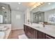 Bright bathroom featuring a double vanity, soaking tub, and a glass-enclosed shower with modern fixtures at 4514 W 34Th Ave, Denver, CO 80212