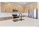 Close-up of a kitchen featuring an island, stainless steel appliances, wood cabinets, and sink at 1904 Water Birch Way, Castle Rock, CO 80108