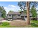 Expansive backyard with a stone patio, ample seating, and mature trees offering shade and privacy at 11035 E Berry Ave, Englewood, CO 80111