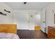 Bright bedroom featuring dark floors, white closet doors, and an open doorway, creating a cozy yet spacious feel at 11035 E Berry Ave, Englewood, CO 80111