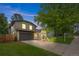 Charming gray two-story home featuring a well-manicured lawn, mature trees, and inviting curb appeal at 11035 E Berry Ave, Englewood, CO 80111