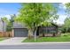 Charming gray two-story home featuring a well-manicured lawn, mature trees, and inviting curb appeal at 11035 E Berry Ave, Englewood, CO 80111
