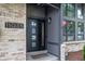 Inviting front entrance featuring a stylish black door with glass accents and brick and gray siding at 11035 E Berry Ave, Englewood, CO 80111