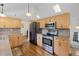 Bright kitchen featuring stainless steel appliances, granite countertops, and wood cabinetry at 11035 E Berry Ave, Englewood, CO 80111