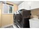The laundry room features modern appliances and storage at 11035 E Berry Ave, Englewood, CO 80111