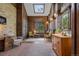 Bright living room with skylight, wood paneling, brick floors, and cozy seating arrangement at 11035 E Berry Ave, Englewood, CO 80111