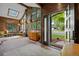 Bright living room with skylight, wood paneling, brick floors, and a view of the front yard at 11035 E Berry Ave, Englewood, CO 80111