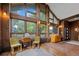 Bright living room with wood paneling, large windows, brick floors, and an open floor plan at 11035 E Berry Ave, Englewood, CO 80111