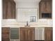 Basement wet bar with modern cabinetry and wine cooler at 1571 Arrowpoint Ct, Franktown, CO 80116