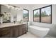 Modern bathroom with soaking tub, double vanity, and marble accents at 1571 Arrowpoint Ct, Franktown, CO 80116