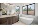 Modern bathroom with soaking tub, double vanity, and marble accents at 1571 Arrowpoint Ct, Franktown, CO 80116