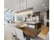 Elegant dining area with a large wood table and modern light fixture at 1571 Arrowpoint Ct, Franktown, CO 80116