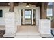 Modern front entrance with a glass door and brick columns at 1571 Arrowpoint Ct, Franktown, CO 80116