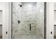 Modern shower with marble tile and glass enclosure at 1571 Arrowpoint Ct, Franktown, CO 80116