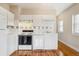 Functional kitchen with white appliances, tile backsplash, and hardwood floors at 1351 N Washington St # 23, Denver, CO 80203