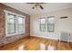 Bright living area with exposed brick, hardwood floors, and radiator at 1351 N Washington St # 23, Denver, CO 80203