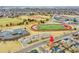 A house in a neighborhood adjacent to a school complex complete with athletic facilities and parking areas at 14425 E 50Th Ave, Denver, CO 80239