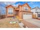 Two-story home with brick and wood accents, featuring a two-car garage and well-manicured front yard at 14425 E 50Th Ave, Denver, CO 80239