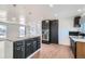 Kitchen with a granite island, sleek black cabinetry, stainless steel appliances, and wood flooring at 9955 Fillmore St, Thornton, CO 80229