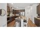 Contemporary kitchen with an island, dark cabinets, stainless steel appliances, and bar stool seating at 27593 E 1St Pl, Aurora, CO 80018