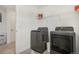 Convenient laundry room with modern washer and dryer, and overhead shelving at 27593 E 1St Pl, Aurora, CO 80018