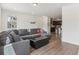 Spacious living room featuring a large grey sectional sofa and a seamless transition into the kitchen area at 27593 E 1St Pl, Aurora, CO 80018