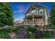 Inviting covered porch with seating offers views of the beautifully landscaped front yard at 881 Kirby Ct, Watkins, CO 80137