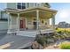 Inviting covered porch with elegant columns, offers a relaxing outdoor space and garden views at 881 Kirby Ct, Watkins, CO 80137