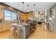 Open kitchen featuring granite countertops, stainless steel appliances, large windows, and island with seating at 881 Kirby Ct, Watkins, CO 80137